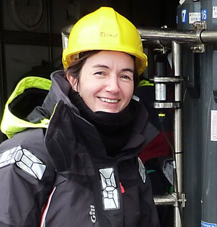 Support scientist Sharon McNeill next to water collecting equipment on oceanographic fieldwork